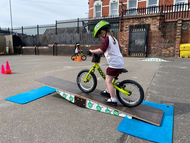 Children practising cycling in school playground